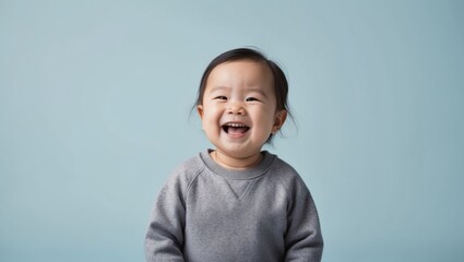 A joyful toddler is smiling against a blue background