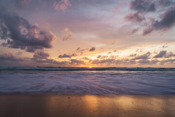pink and orange sunset with clouds at karong beach in phuket
