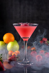 Cocktail glass with fresh fruits, apples, strawberries, kumquats and blueberries making a splash with the liquid flying
