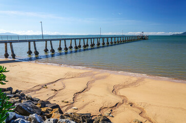 Fototapeta premium Pier and golden beach in Cardwell town in Queensland, Australia. Cardwell&nbsp;is coastal town and rural locality&nbsp;in Cassowary Coast Region.