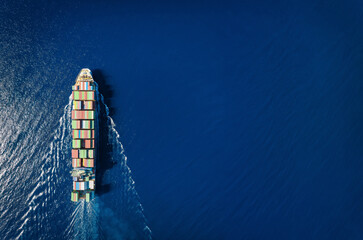 High aerial top view of a commercial container cargo ship in motion with copy space as a concept...