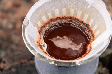 Coffee filter. Top view. Close-up. Foam on coffee. Coffee aroma. Trendy coffee in nature. Autumn atmosphere. Forest. Coffee on the road. Coffee in the forest