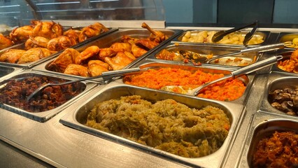 sale of side dishes and grilled chicken in a supermarket, cafe behind the counter in metal containers by weight. side view selection