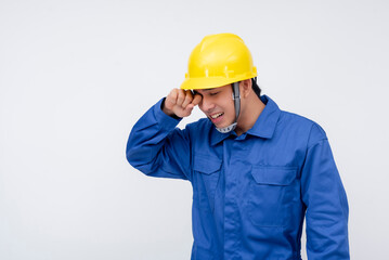 A worker rubs his eyes in fatigue, showing the effects of physical strain and tiredness. Perfect for themes of workplace exhaustion, overexertion, and job-related stress.