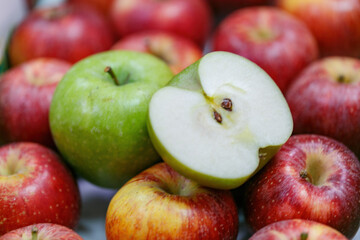 Fresh apples red and green varieties, perfect for healthy snacking or baking ideas. The image features a sliced green apple among whole red apples, inviting thoughts of healthy recipes and snacks.