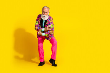 Full size photo of handsome pensioner mister touch show biceps dressed colorful pink classy garment isolated on yellow color background