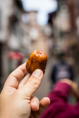 Un Canelés bordelais dans la main d'un homme, pâtisserie française