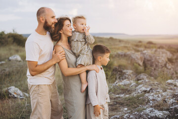 Fototapeta premium Happy Family Enjoying Nature Together During a Peaceful Sunset in the Countryside