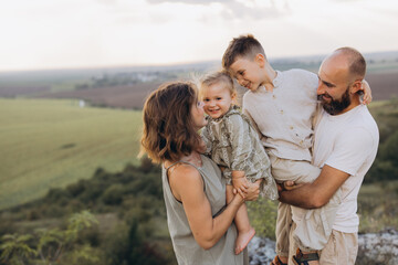 Happy Family Bonding Outdoors in Nature During Sunset with Children Smiling