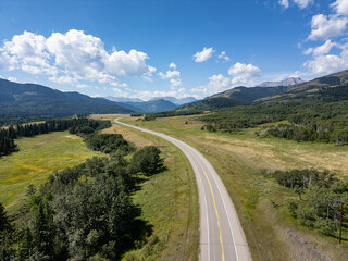 Scenic Open Road and Lush Greenery Under Blue Skies in Alberta, Canada