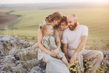 Fototapeta premium Happy Family Bonding Outdoors in Nature During Sunset on a Warm Evening
