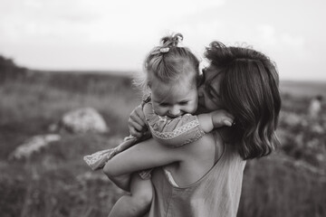 Tender Moment Between Mother and Daughter in a Serene Outdoor Setting Captured in Black and White...