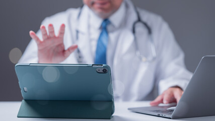 Healthcare professional conducts telemedicine session, using tablet for consultation while...