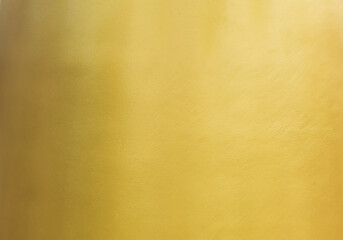 Gold wall texture background. Yellow shiny gold paint on concrete wall surface, vibrant golden...