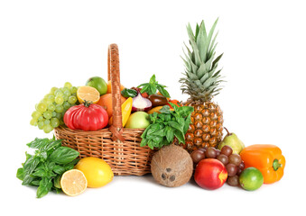 Different fresh fruits and vegetables in wicker basket isolated on white