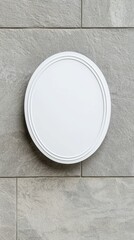 A white oval shaped mirror is hanging on a gray wall