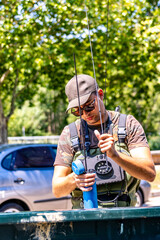 angler organizing fishing rods near vehicle