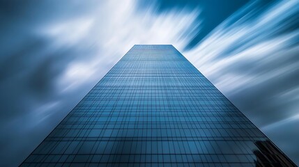 Fototapeta premium A Tall Glass Skyscraper Against a Blurry Blue Sky