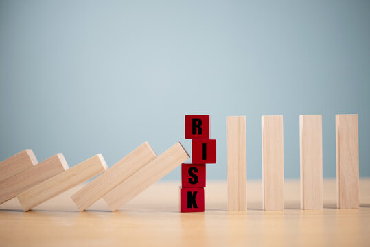 Risk management crisis concept. Financial analysis solution, real estate business. Stop economic risk assessment. Risk word on wooden block, domino crisis reduce effect. Insurance security assessment
