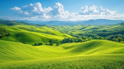 Obraz premium Lush green rolling hills under a bright blue sky with clouds.