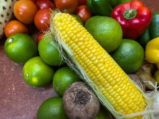Fresh corn isolated with fruits background. Selective focus.