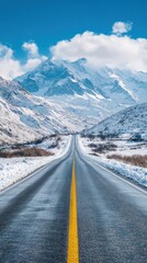 Naklejka premium Straight Road Leading to Snowy Mountains Under Clear Blue Skies