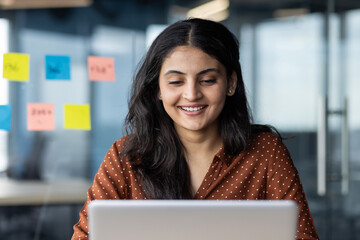 Closeup employee company smiling works with a laptop, a business woman is satisfied with the...