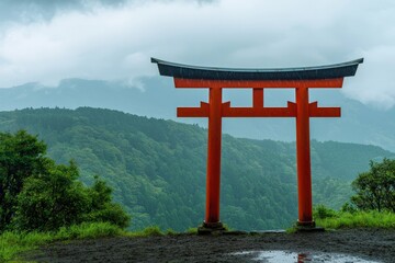 A traditional Japanese torii gate painted in vivid red, standing tall against a serene mountain backdrop