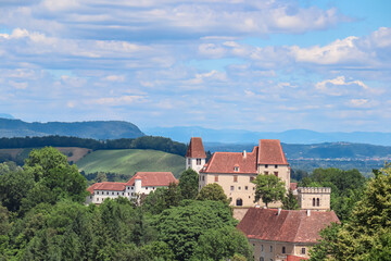 Obraz premium Panoramic view of historic Seggau castle on hill Seggauberg in Leibnitz, south west Styria, Austria, Europe. Idyllic landscape with trees and rolling hills. Peaceful serene atmosphere in summer