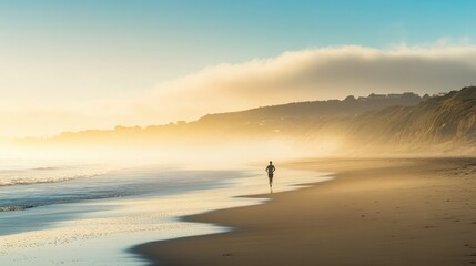 An early morning beach scene with a lone jogger running along the shore, the mist rising from the sea and the sun low on the horizon.