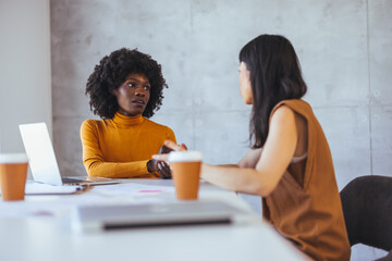 Two Women Engaged in Intense Business Meeting at Office Table