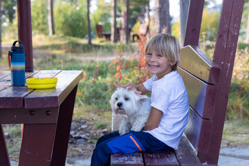 Cute blond child, eating lunch in a campside along the road in Norway