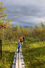 Family with kids and dog, hiking the Abisko National Park near Kiruna on a summer day