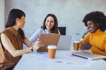 Diverse Group of Women in a Business Meeting Laughing Together