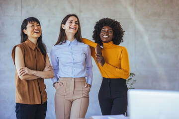 Diverse Group of Women Laughing in a Modern Office Setting