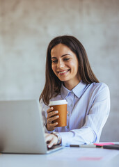 Woman Enjoying Coffee While Working on Laptop at Home