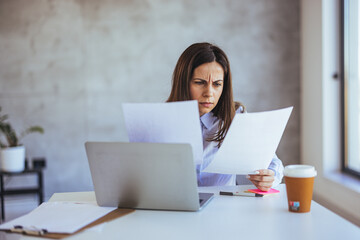 Focused Woman Analyzing Documents in Modern Office