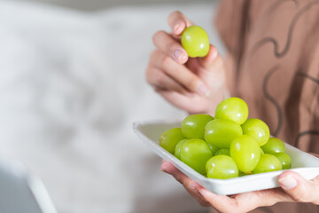 Hand Reaching for Fresh Green Grapes