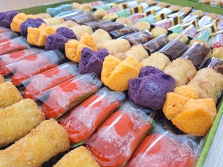 Variety of colorful traditional Indonesian snacks, known as jajanan pasar are neatly arranged and colorful. Some of the types include risoles, kue ku, and kue apem. sweet, savory, and very delicious. 