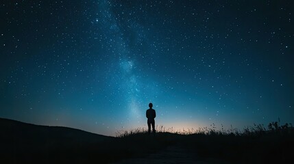 Fototapeta premium Stunning night sky with a galaxy of stars and a silhouette of a person stargazing