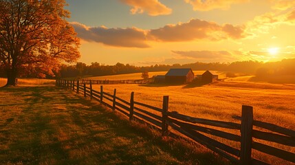 Obraz premium Wooden fence runs along a golden pasture with a rustic barn under a warm autumn sunset.
