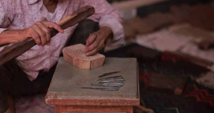 Person making handcrafted products with traditional methods, namely wooden blocks