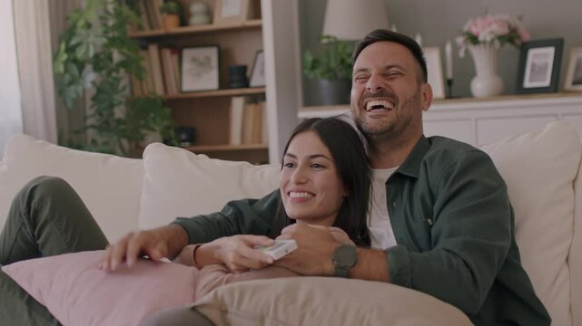 Woman and man enjoying a cinematic experience with smiles and popcorn in the living room. 4k video