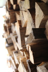 a wall of cut logs and sunlight at the end