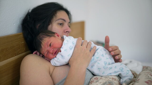 Mother comforting a crying newborn on her chest, offering warmth and security, capturing a moment of maternal care and deep connection in a quiet and intimate setting