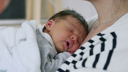 Newborn baby rests on mother’s chest, enveloped in a cozy blanket, symbolizing the intimate bond and the comfort of maternal care in a peaceful, nurturing environment