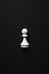 white pawn chess piece on black background