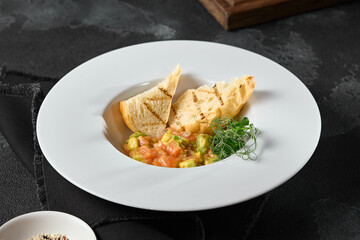 Elegant Salmon Tartare with Avocado and Ciabatta Toasts in Moody Lighting