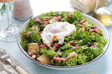 A bowl with salad lyonnaise served for lunch	