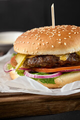 Juicy Beef Burger on Sesame Bun with Fresh Veggies and Cheddar Cheese